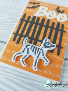 Geschenkumschlag in Kürbisgelb mit Zaun, einem Skeletthund und dem Wort BOO