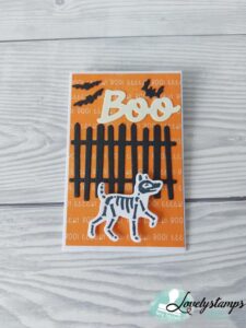 Geschenkumschlag in Kürbisgelb mit Zaun, einem Skeletthund und dem Wort BOO